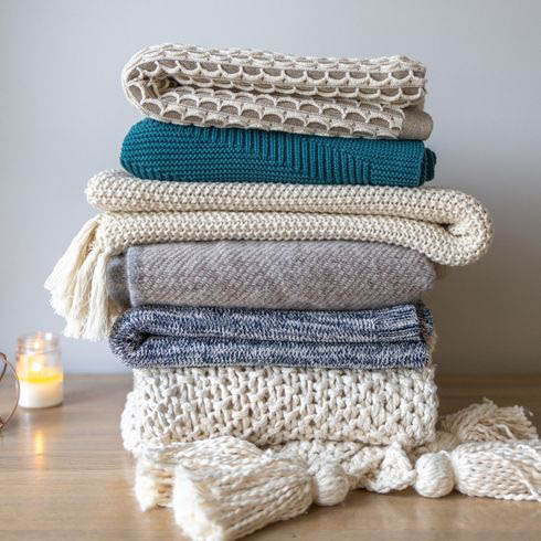 a stack of folded knit blankets