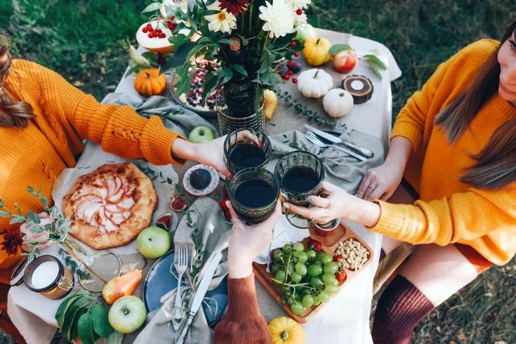 Friends having an outdoor dinner party in the fall. 