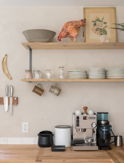 Floating wooden shelves above a wooden countertop with a coffee maker