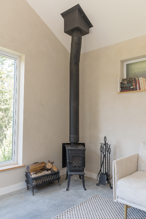 A small wood burning stove in the corner of a cottage living room