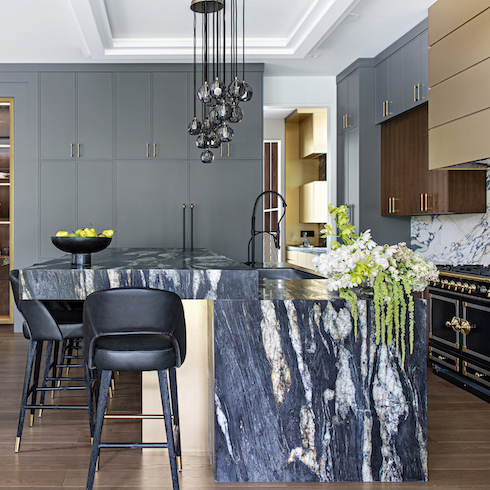 Luxurious kitchen by Marla Nazzicone Design uses materials make for a wildly interesting place such as marble with a leathered finish, solid brass lines the front of the island and the hood, and walnut cabinetry