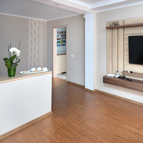 Small white apartment with cork flooring and a large TV hung on the wall as part of a home reno trends story for HGTV Canada