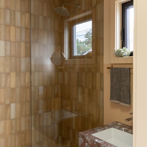 Mustard-toned tiles in small shower - bathroom of Toronto laneway house