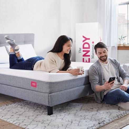 Endy boxed mattress and a couple hanging out in their bedroom