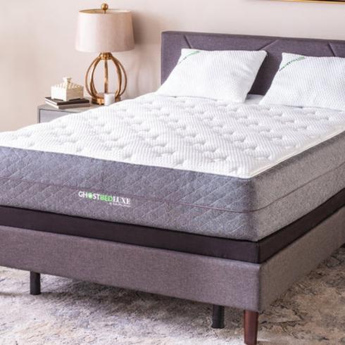 A Ghostbed mattress in a bedroom with a nightstand and a bedside lamp