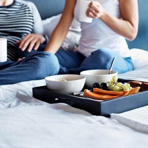 A couple eating breakfast on a bed
