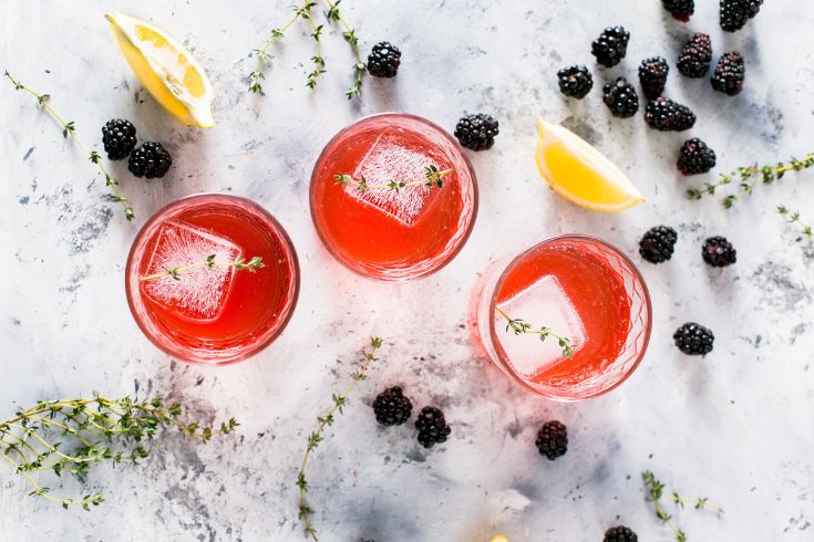 Cocktails mixed with fruit juice, blackberry , lemon slices and herbs 