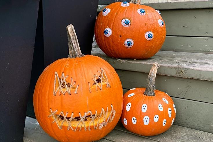 three pumpkins decorated using easy jack-o-lantern designs 