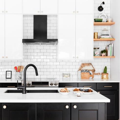 A black kitchen island with white cabinets