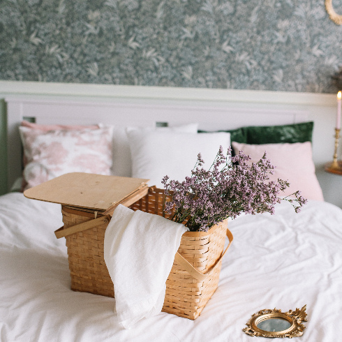 A bedroom with vintage-inspired floral wallpaper and girly details