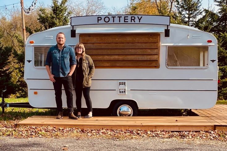 Brett and Natasha in front of their pottery trailer