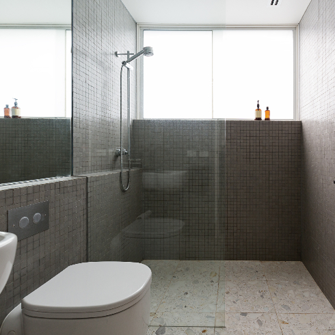A modern grey bathroom with a terrazzo tile floor