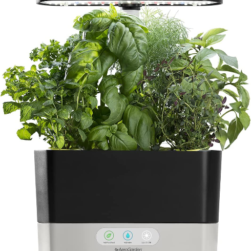 Product shot of AeroGarden Harvest with fresh herbs growing