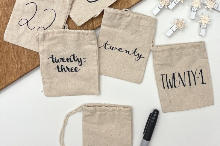 Canvas bags with various dates written on it as part of a DIY advent calendar craft 