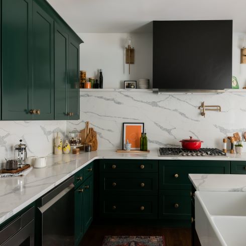 Dark green cabinets with light white countertop and backsplash