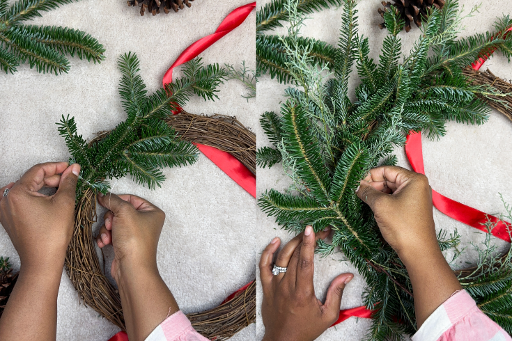 Hands attaching evergreen branches to a grapevine wreath base - easy wreath tutorial