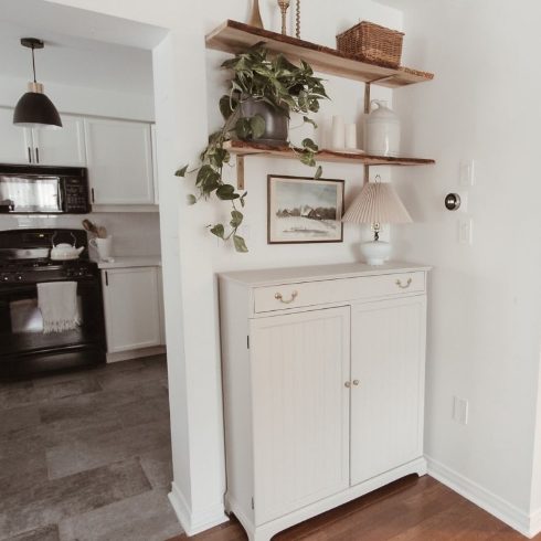 Open shelving in a foyer above a cabinet