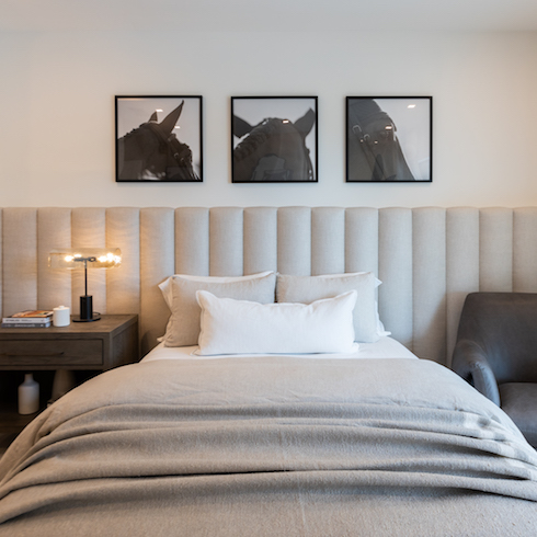 Bed with grey headboard and horse photos
