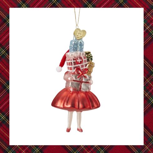 Ornament of a girl in a red dress holding gifts
