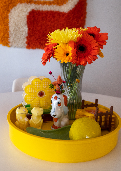 Details of flowers and ceramics on the dining room table in a sunny yellow and orange shade