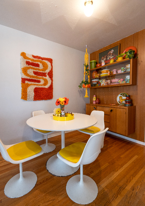 A shot of the dining room area with vintage chair and table and orange and yellow accents