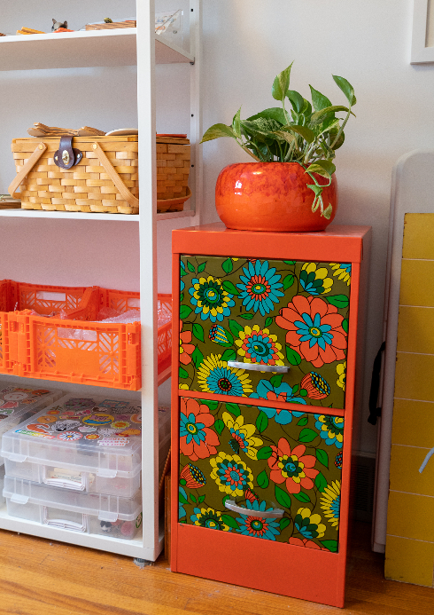 A shot of an orange and retro floral patterned filing cabinet
