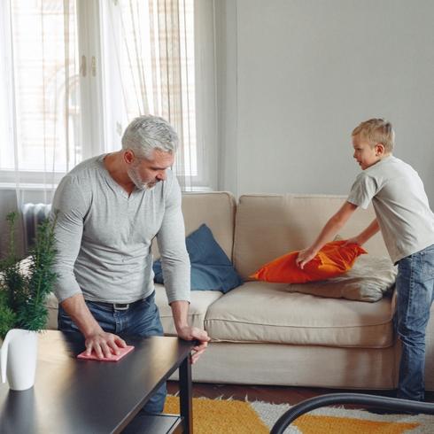 A dad and son cleaning living room rogether