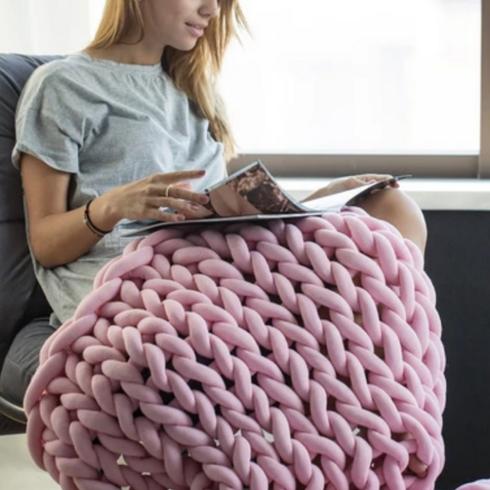 Woman snuggled up with pink knit blanket