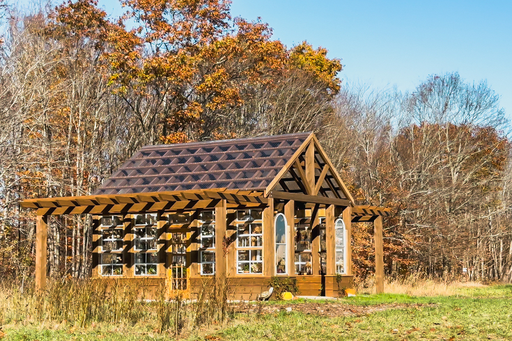 An exterior shot of the wooden greenhouse on the A-Frame property