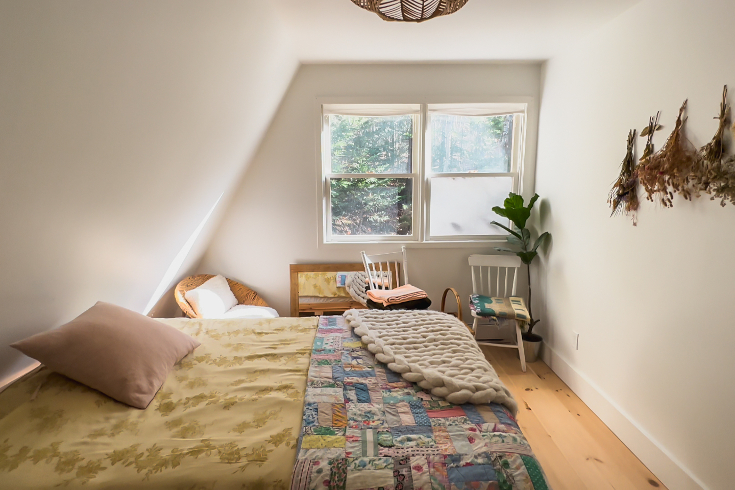 The guest bedroom with a bed with a yellow quilt and a handmade patchwork quilt