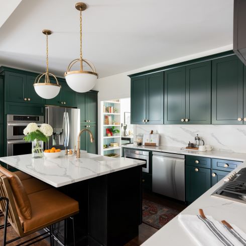 Cotemporary kitchen with rich, dark green cabinets and white countertops