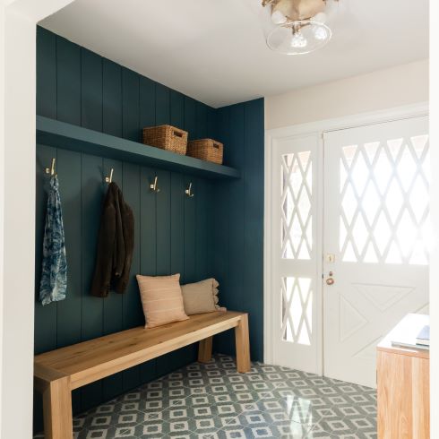Entryway with dark blue, coat-hooked feature wall
