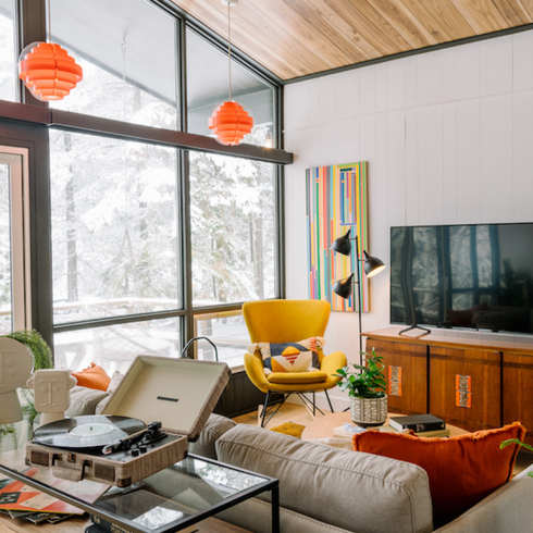 light filled living room with mid century colours and textures and orange pendant lights