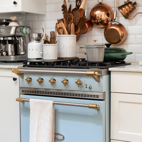 cornflower blue vintage looking stove with copper pots and pans