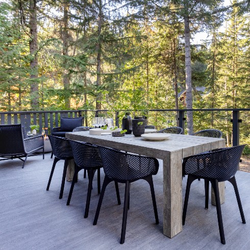 Outdoor dining deck with black chairs and wood table