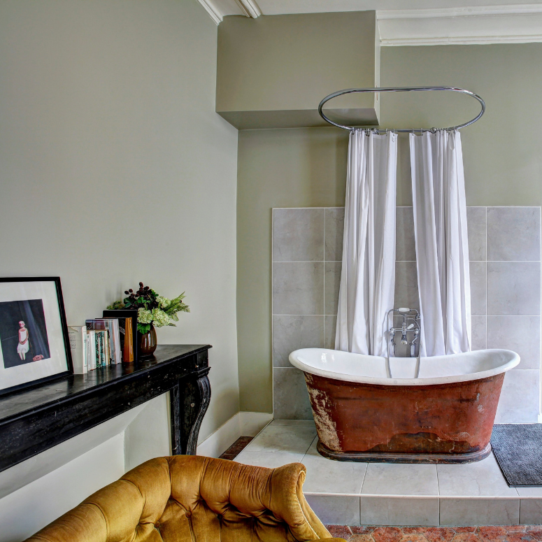 Bathroom with a copper tub with bright mustard couch