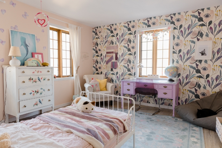 A child's bedroom with bold pink printed wallpaper.