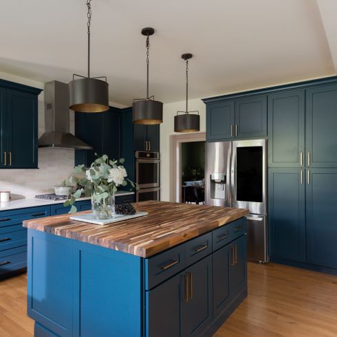 Blue kitchen cabinets with luxurious wooden floors and island top