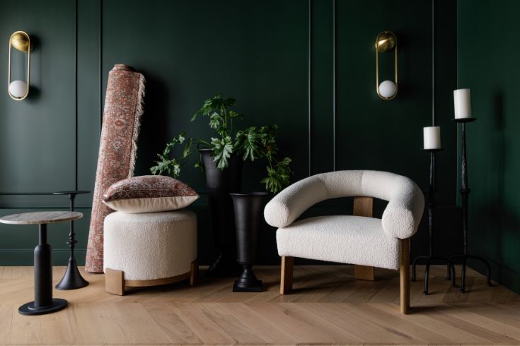 Dark green painted walls, white arm chair and ottoman 