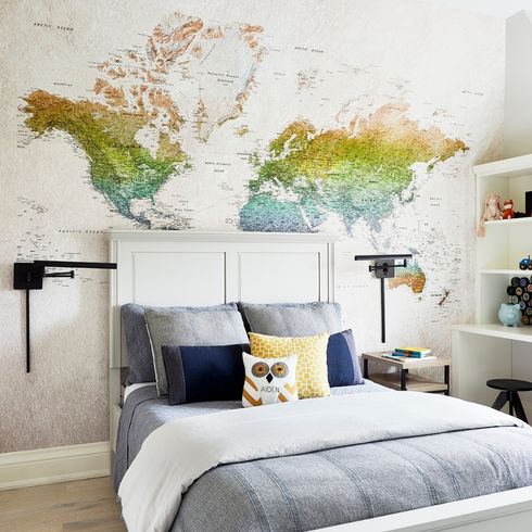 Boy's bedroom with map wallpaper and black sconces