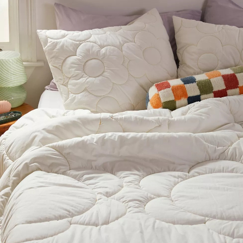 A white cotton bedspread with oversized daisy pattern