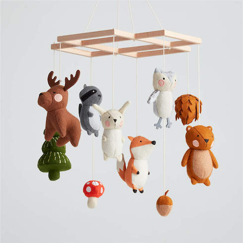 Woodland-themed mobile featuring a plush moose, bunny, raccoon, fox, pine tree, pine cone, acorn and mushroom from Crate & Barrel