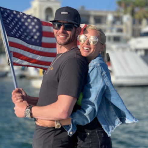 Heather Rae and Tarek El Moussa holding a US flag on the fourth of July