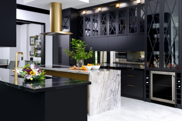 A black kitchen with gold and marble accents. 