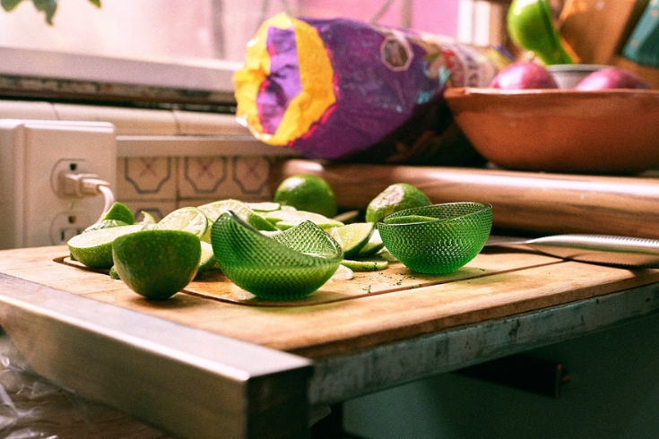 Green bowls on a cutting board with limes 