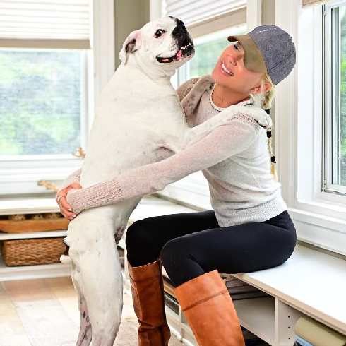 A shot of Galey Alix hugging her large white dog