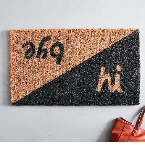 A black and brown front door mat that says hi and bye