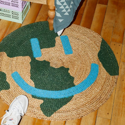 A front door mat with a smiling earth