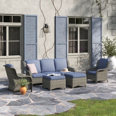 A five-person all-weather wicker outdoor seating set with two ottomans, a three-seat sofa and two chairs