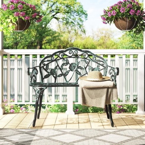 A floral-accented metal park bench for a yard or garden